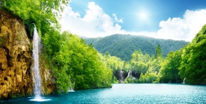 عکس با کیفیت بالا طبیعت زیبای آبشار و دریاچه با درختان و کوه های زیبا در تابستان و آسمان آبی یا دانلود عکس با کیفیت طبیعت بکر و کوه و جنگل و چشم انداز