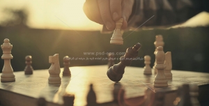 عکس با کیفیت بازی شطرنج و زدن مهره وزیر با زمینه غروب آفتاب با مهره ها و تخته چوبی شطرنج