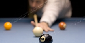 عکس با کیفیت بازیکن بیلیارد در حال زدن توپ مشکی با توپ سفید رنگ