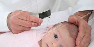 عکس با کیفیت متخصص اطفال در حال معاینه گوش نوزاد توسط اتوسکوپ