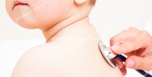 عکس با کیفیت معاینه کودکی توسط متخصص اطفال به وسیله گوشی طبی یا استِتوسکوپ از پشت قفسه سینه