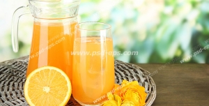 عکس با کیفیت پارچ و لیوان آب پرتقال در کنار برشی از پرتقال بر روی میز