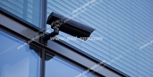 عکس با کیفیت دوربین مدار بسته مشکی رنگ نصب شده در خارج از ساختمان و در کنار پنجره