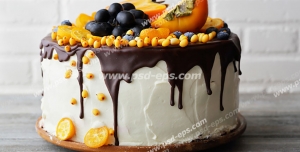 عکس با کیفیت کیک خامه ای با لایه کاکائو بر روی آن و تزئین با تکه های میوه های استوایی