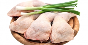عکس با کیفیت تکه های گوشت ران مرغ در کنار چند عدد پیازچه بر روی تخته گوشت
