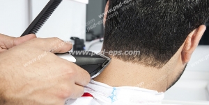 عکس با کیفیت آرایشگر مردانه در حال خط گرفتن موهای سر مشتری با دستگاه موزر