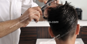 عکس با کیفیت آرایشگر مردانه در حال شانه و مدل دادن به موهای سر مشتری