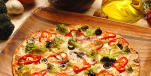 عکس با کیفیت پیتزای نازک ایتالیایی با ظرف چوبی بامبو بر روی میز آشپز در کنار مواد اولیه