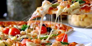 عکس با کیفیت برداشتن برشی از پیتزای قارچ و سبزی با گوجه گیلاسی و پنیر پیتزای فراوان