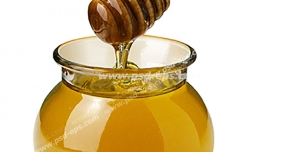 عکس با کیفیت برداشتن عسل از شیشه آن با قاشق مخصوص چوبی بامبو