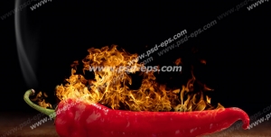 عکس با کیفیت فلفل قرمزی درون آتشی همراه با دود بر روی میز چوبی