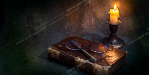 عکس با کیفیت کتاب ، خودکار و عینک در روشنایی نور شمع
