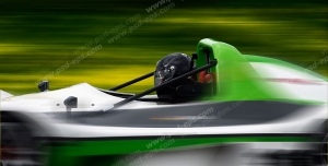 عکس با کیفیت تبلیغاتی ماشین مسابقه سبز در حال مسابقه در پیست سرسبز