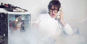 عکس با کیفیت تبلیغاتی مرد در حال صحبت تلفن و کمک خواستن برای تعمیر کیس کامپیوتری که از آن دود بلند شده است
