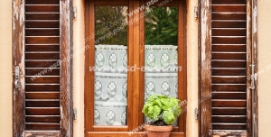 عکس با کیفیت تبلیغاتی پنجره چوبی زیبا با حفاظ چوبی قهوه ای سوخته و یک گلدان سفالی زیبا جلوی آن