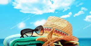 عکس با کیفیت تبلیغاتی کلاه و عینک بر روی حوله لب ساحل