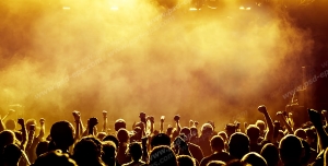 عکس با کیفیت تبلیغاتی مردم در کنسرت در حال شادی زیر نور و دود