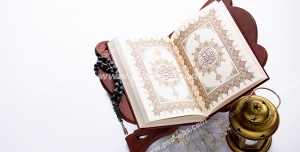 عکس با کیفیت تبلیغاتی قرآن بر روی رحل و فانوس کوچک در کنارش در زمینه سفید