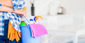 عکس با کیفیت تبلیغاتی سطل وسایل نظافت در دست مرد با لباس چهرخانه آبی در خانه