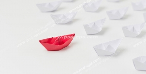 عکس با کیفیت تبلیغاتی قایق های کاغذی سفید پشت سر یک قایق کاغذی قرمز