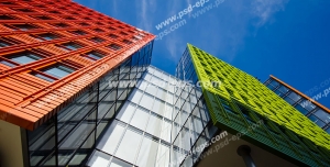 عکس با کیفیت تبلیغاتی ساختمان ها با نمای سبز و نارنجی در زیر سقف آسمان آبی