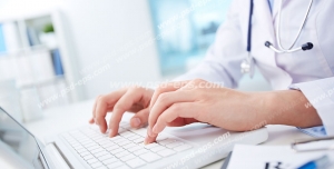 عکس با کیفیت تبلیغاتی پزشک با روپوش سفید در حال کار کردن با لپ تاپ